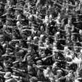 El hombre cruzado de brazos en medio del saludo nazi