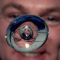 Asombroso efecto de un astronauta mirándose en una gota de agua en el espacio