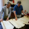 Dos concejales toquetean un pergamino deteriorado del siglo XV para hacerse una foto