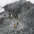 Fotografía sin editar de bomberos en el Santuario del volcán Ontake