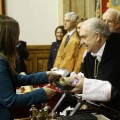 Una investigadora recoge su premio mostrando su billete para salir de España