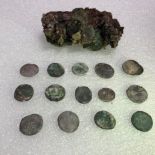 La fotografía muestra 14 monedas y los restos del saquito que llevaba el hombre apretado contra el pecho.Nuevo hallazgo