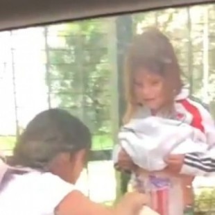 Una madre pega bengalas a su hijo en el cuerpo antes de entrar al Monumental para la final de la Copa Libertadores