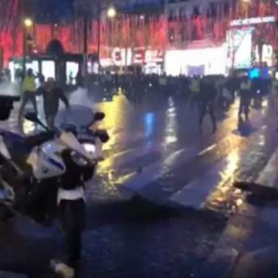 Un policía apunta con su arma a la multitud en una nueva protesta de los 'chalecos amarillos' en París