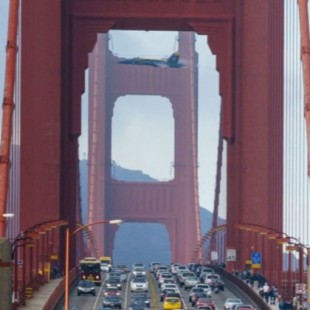 F-18 en vuelo de demostración entre las torres del Golden Gate, mientras circulan por él coches y peatones (2014)