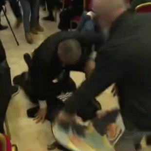 Una espontánea le enseña a Marine Le Pen su foto con Putin y la arrastran fuera de la rueda de prensa