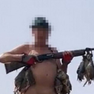 Un cazador posa desnudo con una perdiz atada a sus genitales y al grito de "Arriba España"