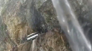 Un autobús en un horripilante viaje por una cascada, en un estrecho paso de montaña, en India