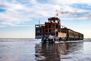 El tren que circula atravesando las aguas de un lago rosa de Siberia