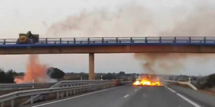 Un agricultor lanza material ardiendo para cortar el paso desde un puente