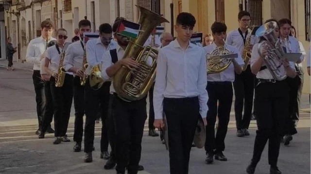 La Banda de Rocafort desafía al alcalde y desfila con una bandera Palestina durante el Corpus