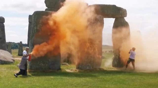 Just Stop Oil rocía Stonehenge con pintura naranja mientras un heroico transeúnte entra para intentar arrastrarlos