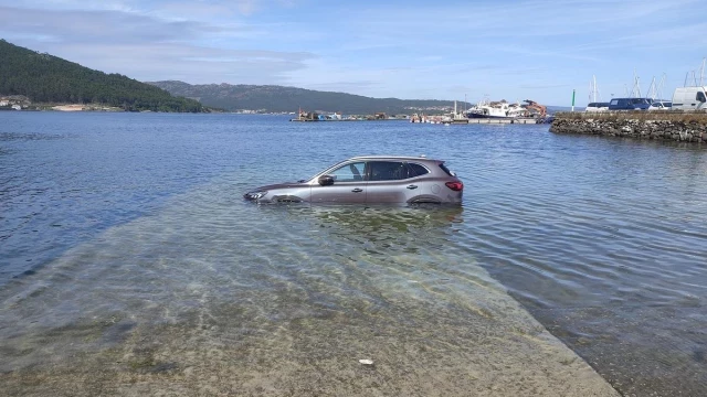 La marea inunda un coche que se encontraba aparcado en el puerto de Muros: "Sempre pasa cos turistas"